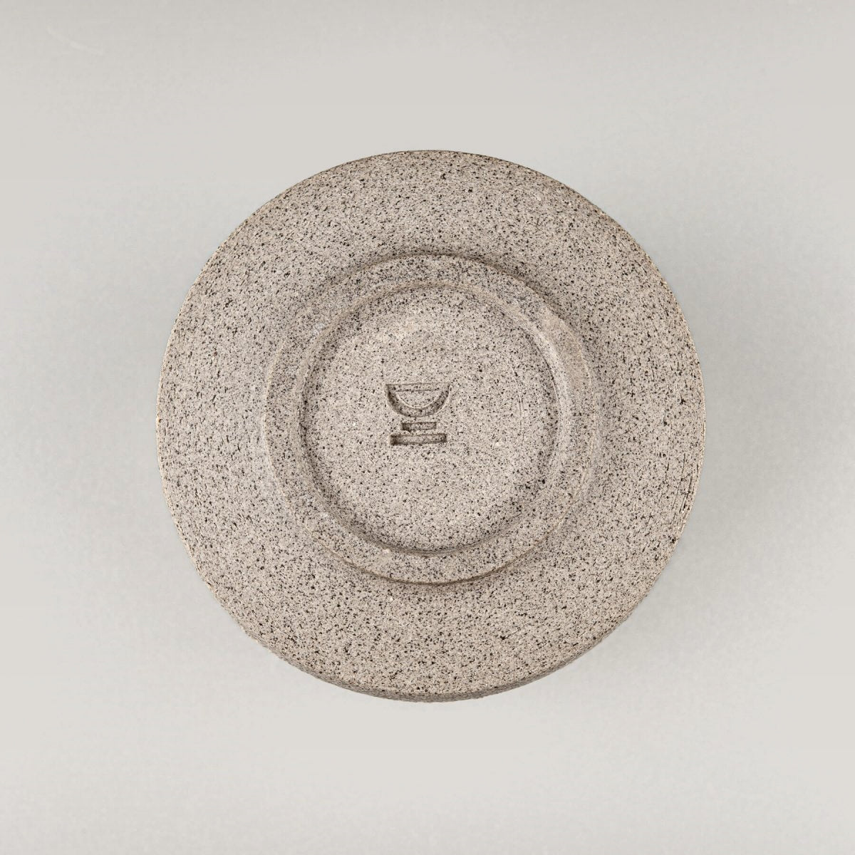Base of pottery coffee mug in dark stoneware clay with handcrafted circular finish.