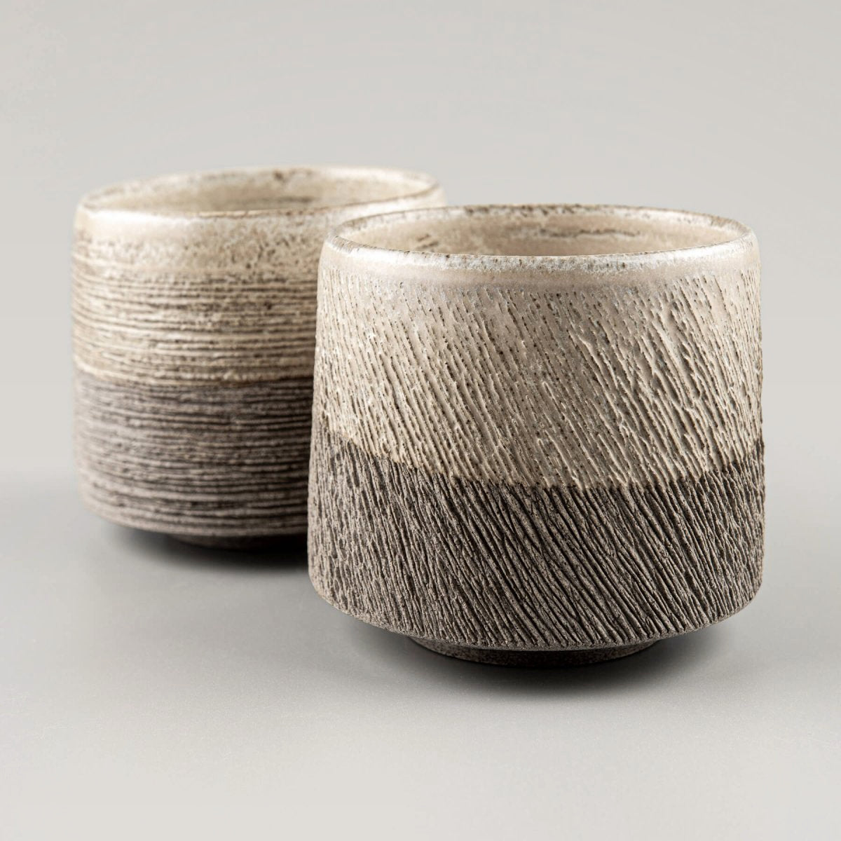 Handcrafted pottery coffee mug set in stoneware with textured carved exterior and matte glaze finish.