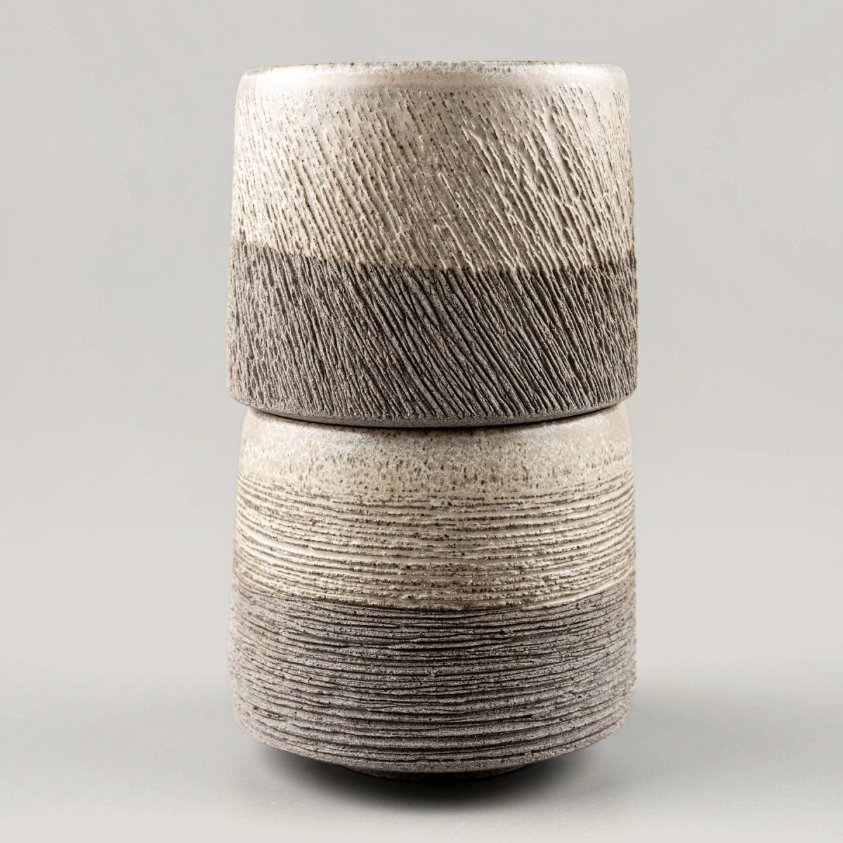 Close-up of pottery coffee mug showing hand-carved stoneware texture and natural matte glaze.
