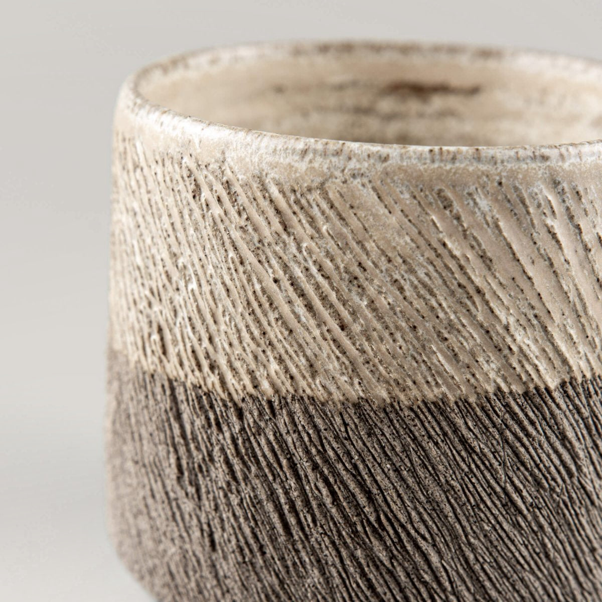 Handcrafted pottery coffee mug with carved stoneware texture and half-glazed matte finish for modern tableware.