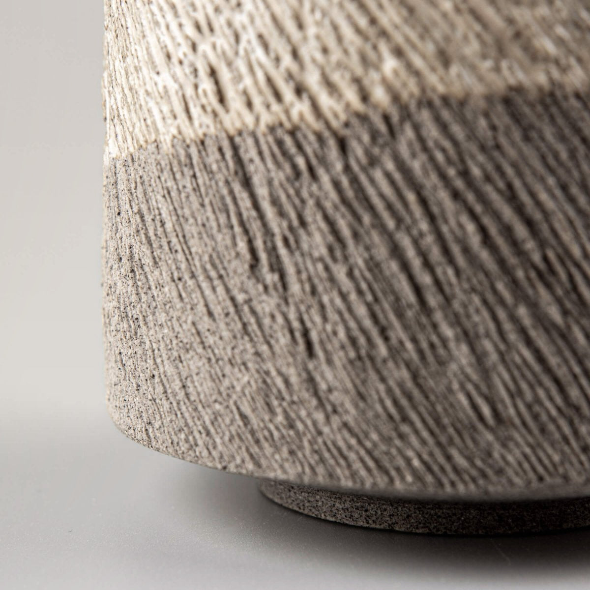 Side view of pottery coffee mug showing textured carved lines and contrasting glaze.