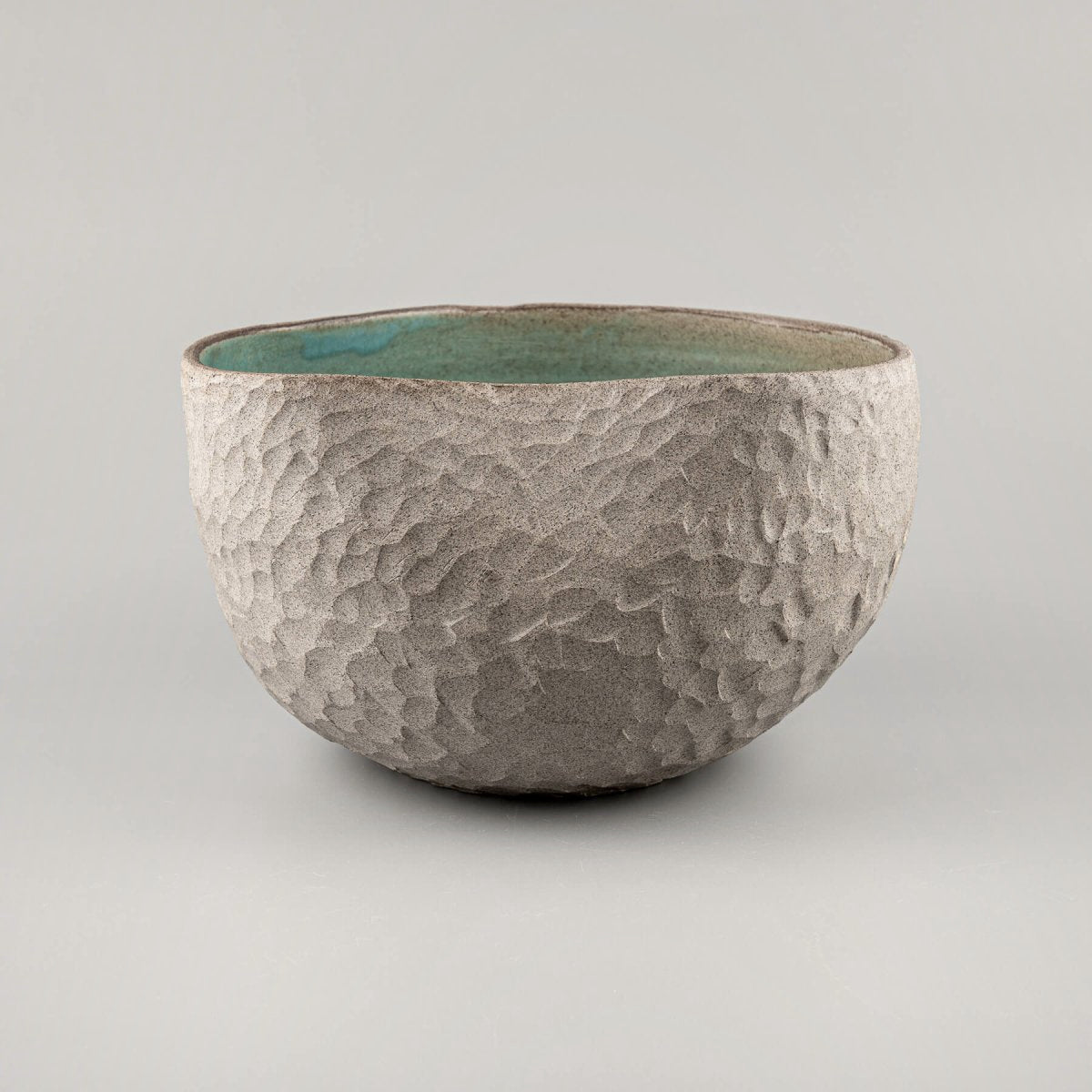 Handmade ceramic vases with a textured stoneware surface and a turquoise-glazed interior, perfect for interior design.
