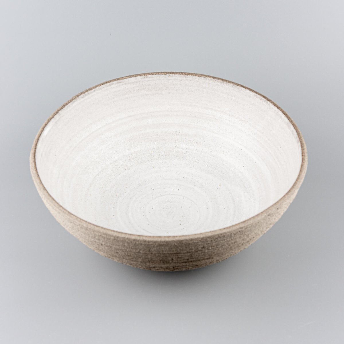 Side view of handmade serving bowl emphasizing the contrast between textured exterior and smooth interior.