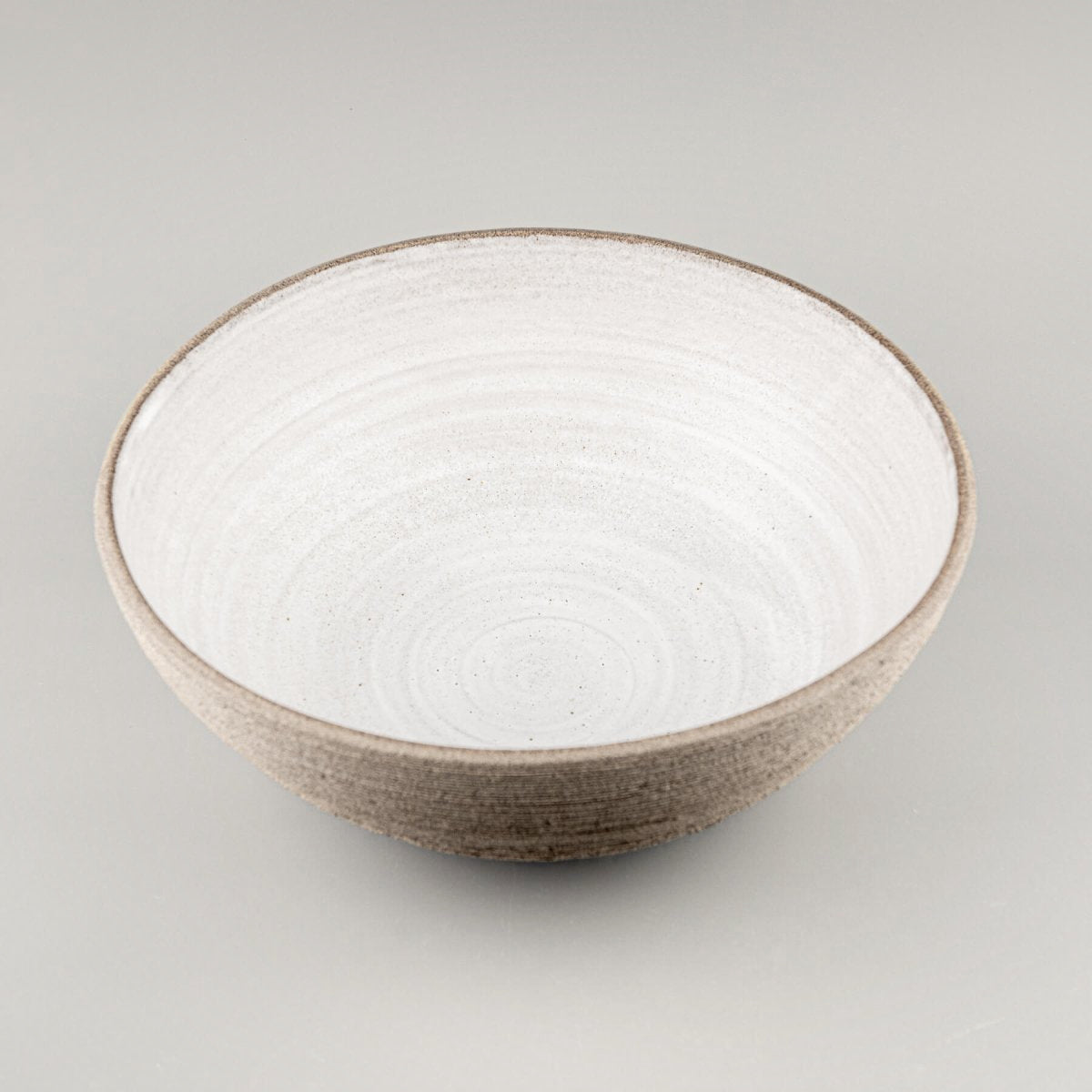Side view of handmade serving bowl emphasizing the contrast between textured exterior and smooth interior.