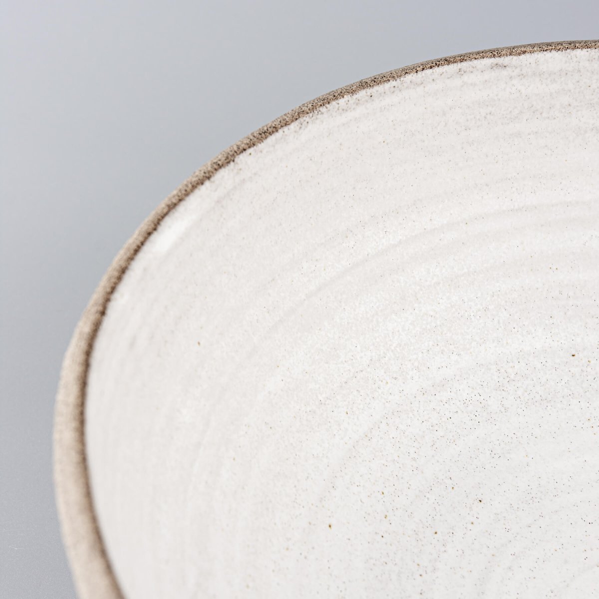 Detailed inner surface of the ceramic bowl with soft matte glaze for sophisticated food presentation.