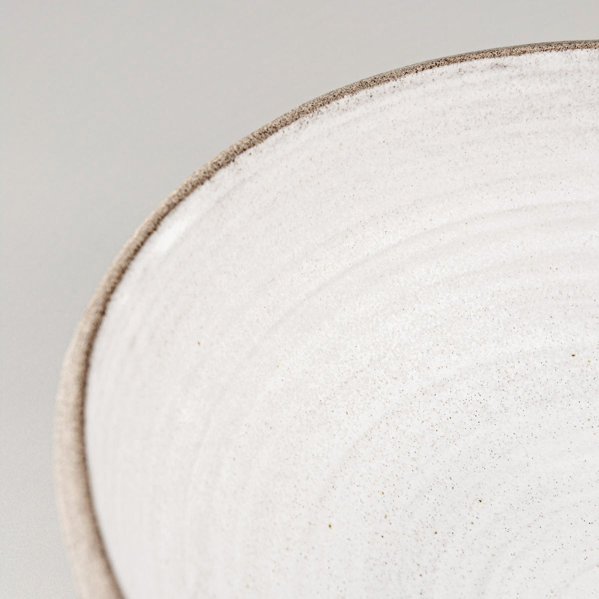Detailed inner surface of the ceramic bowl with soft matte glaze for sophisticated food presentation.