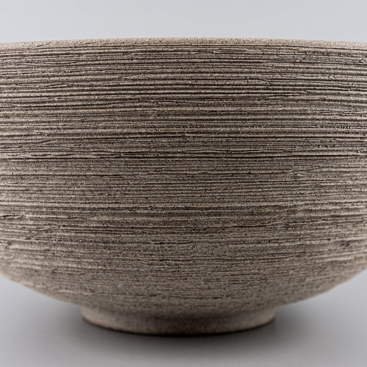 Close-up of the bowl's carved exterior texture, demonstrating artisanal craftsmanship for collectible pottery.