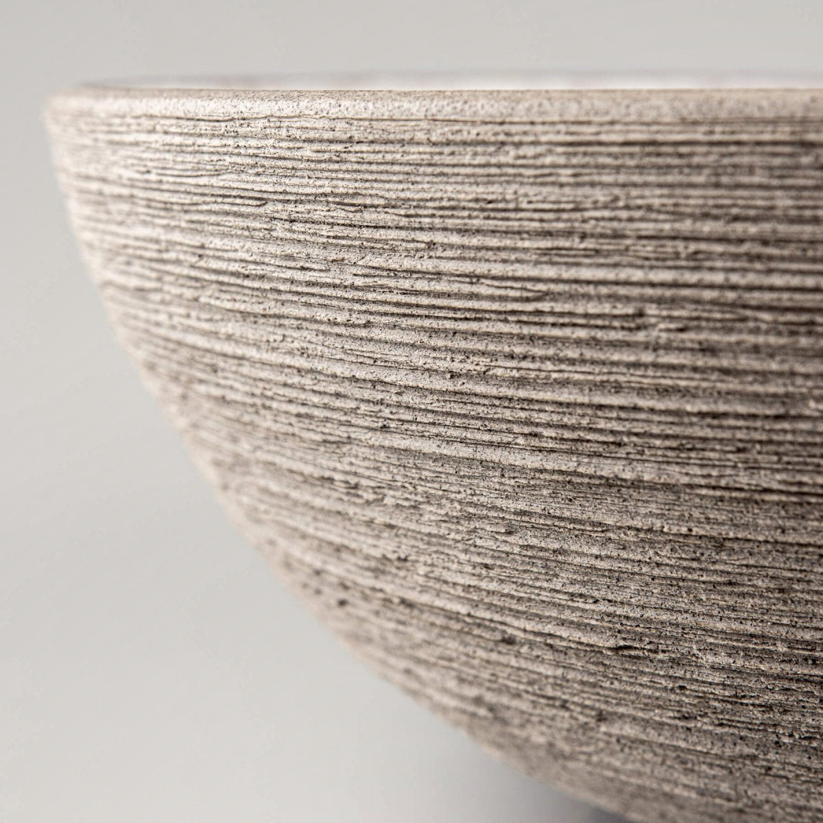 Decorative ceramic bowl angled to highlight the contrast between unglazed exterior and smooth glazed interior.