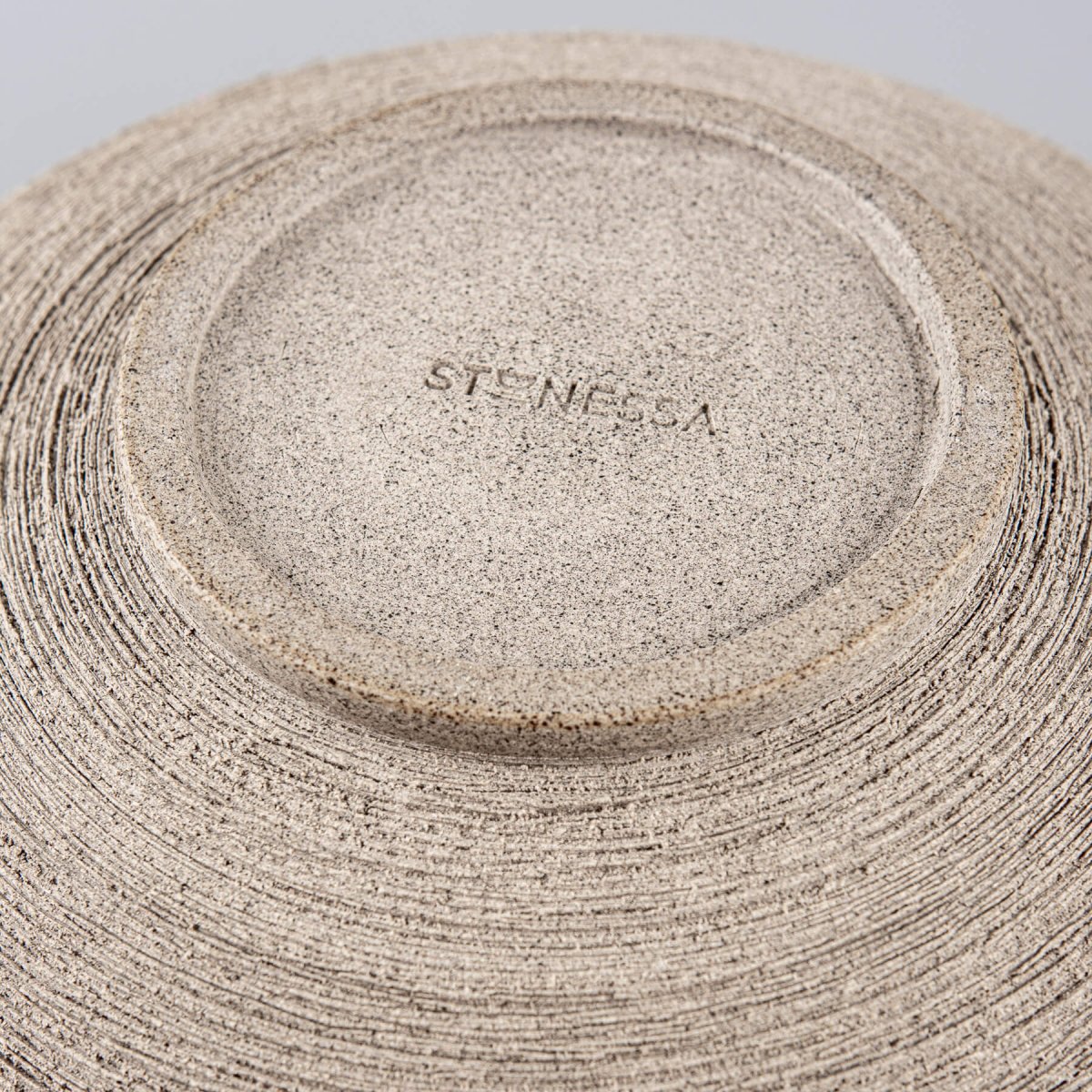 Underside of the handmade bowl revealing the wheel-thrown craftsmanship and raw stoneware detail.