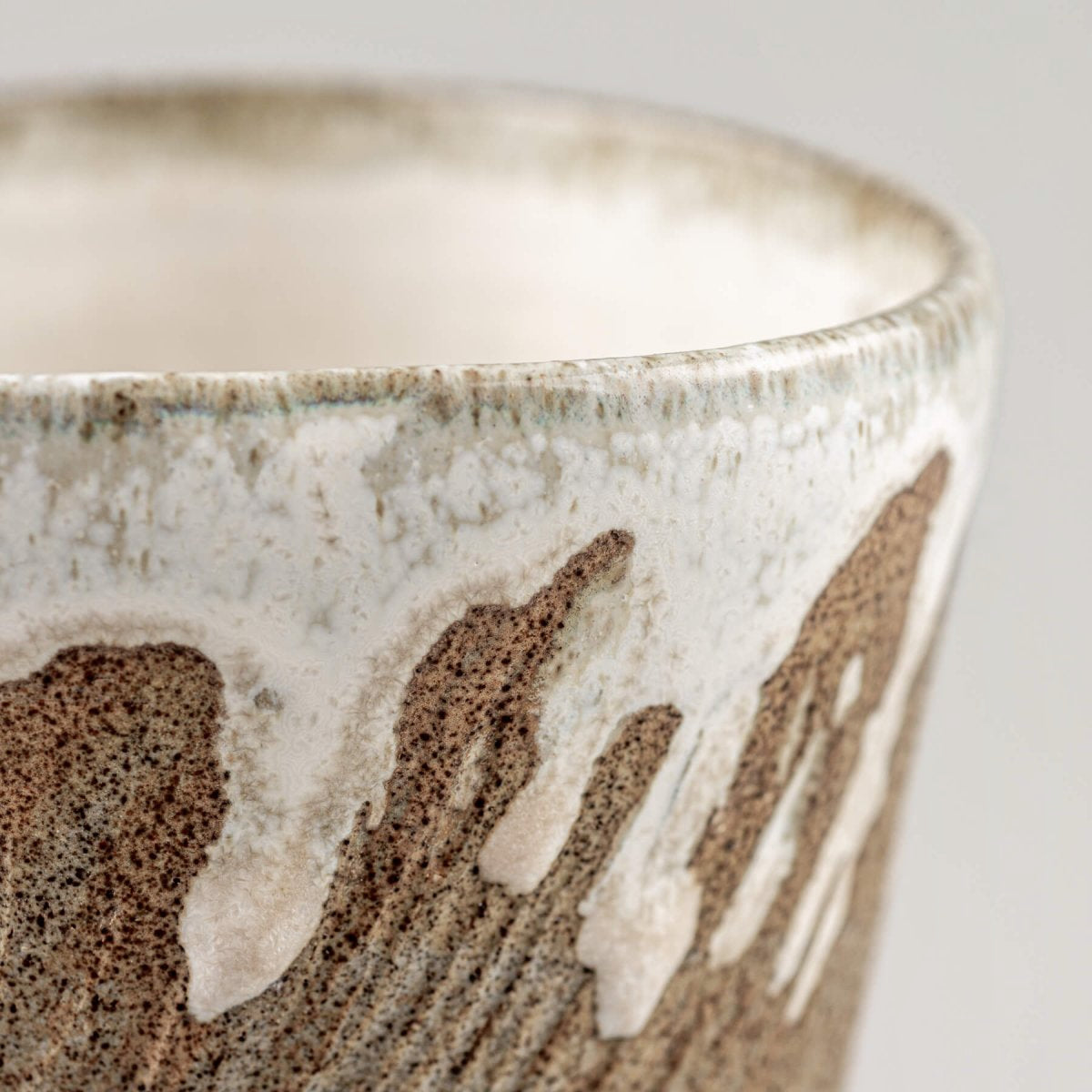 Rustic ceramic espresso mug with tactile carved lines and semi-gloss finish.