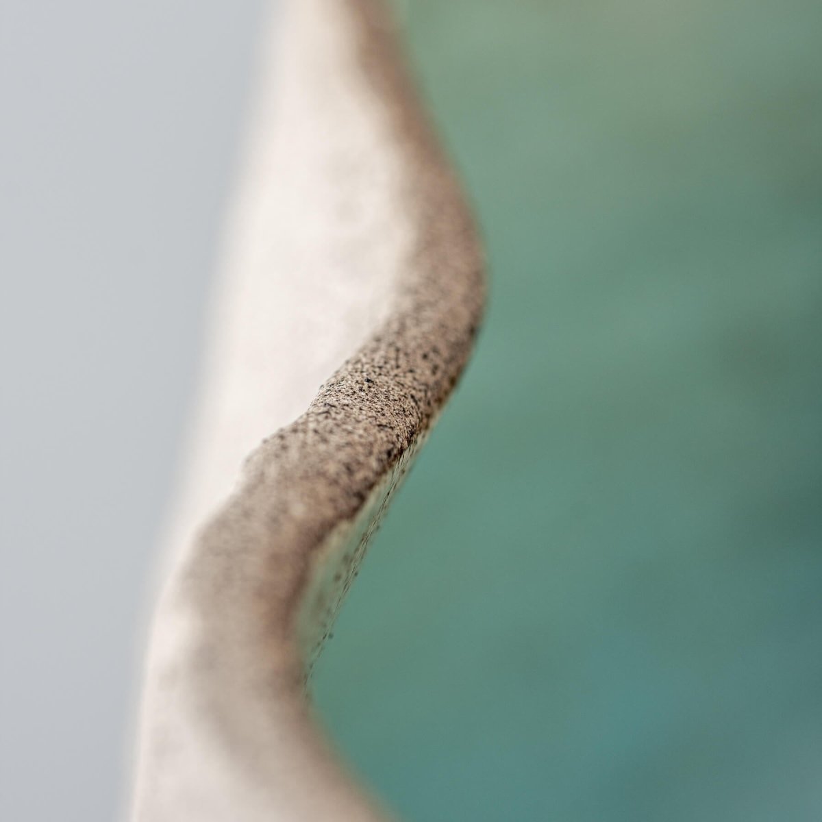 Limited-edition, handmade stoneware vase with a textured surface, ideal for hotels and private collectors.