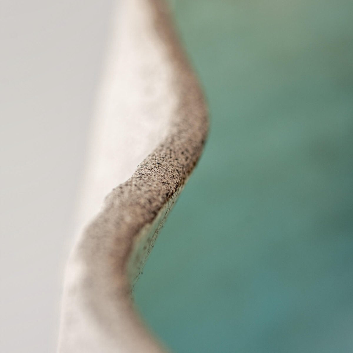 Limited-edition, handmade stoneware vase with a textured surface, ideal for hotels and private collectors.