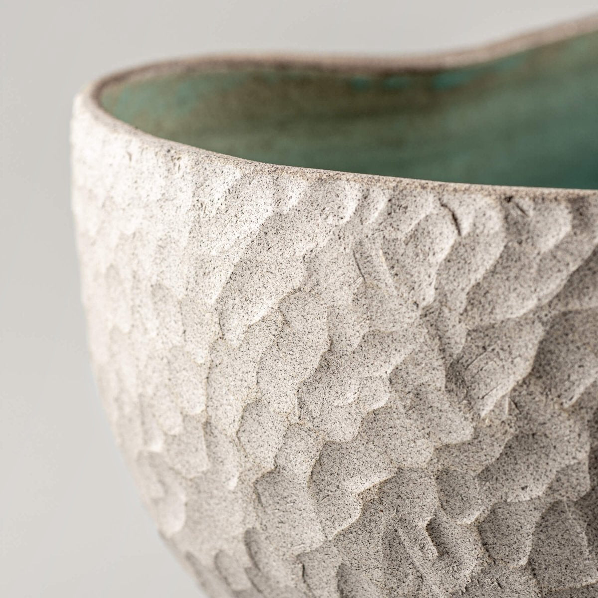 Handmade ceramic vases featuring a carved stoneware texture and a turquoise-glazed interior, suitable for decorative use.
