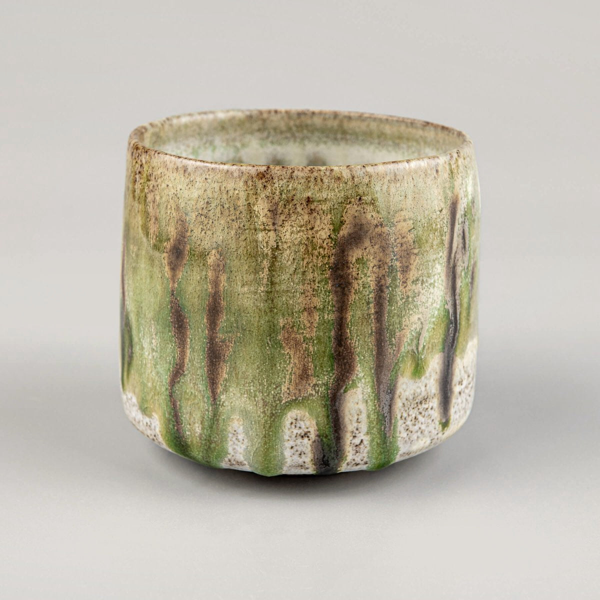 Luxury ceramic coffee and tea mug with earthy green and brown artistic glazing.