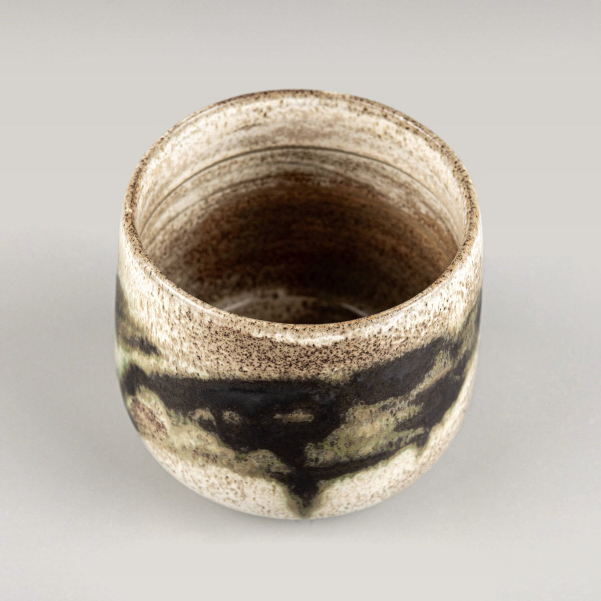Collectible pottery mug crafted from dark stoneware clay for fine dining settings.
