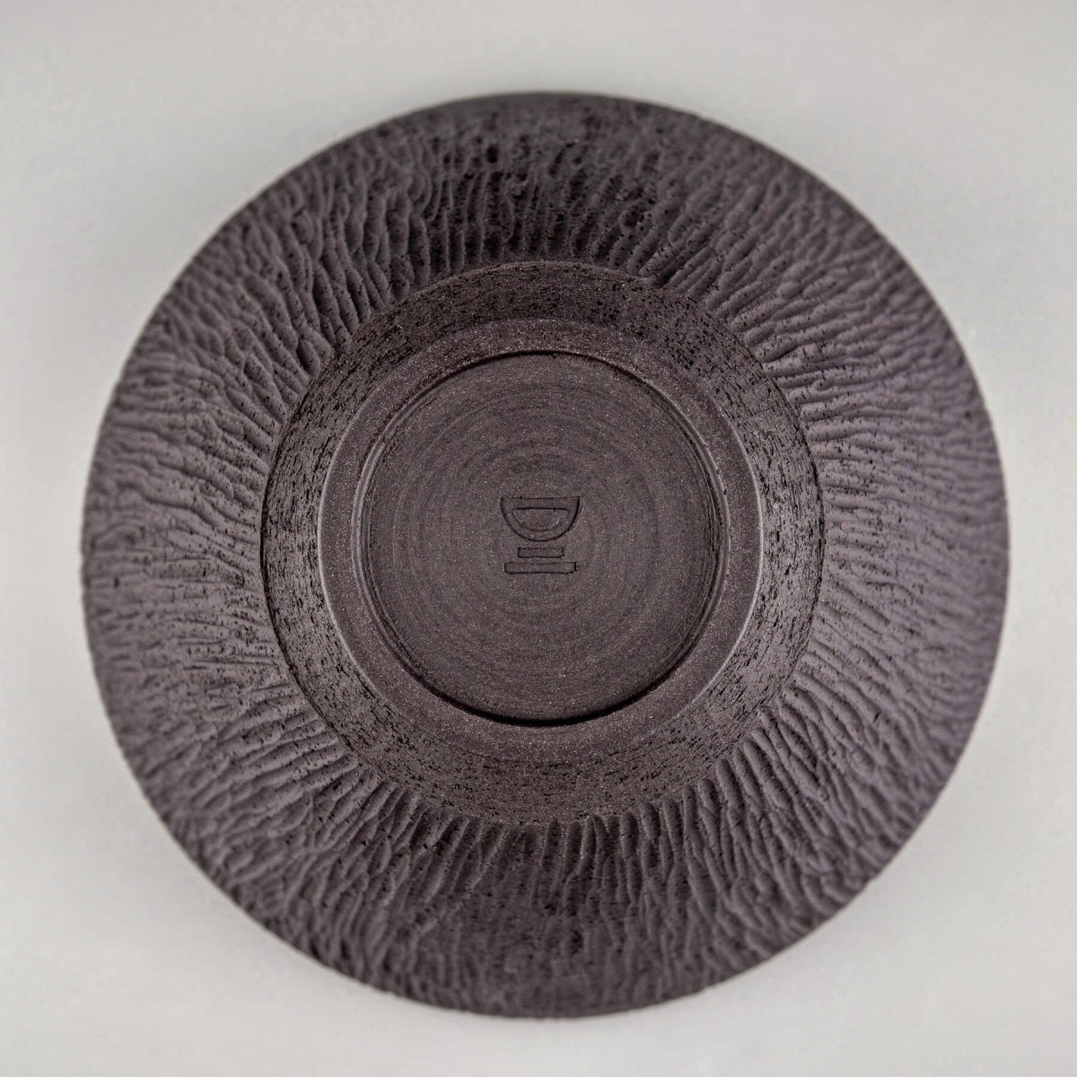 Unglazed base of artisan ceramic bowl showing handcrafted detail.