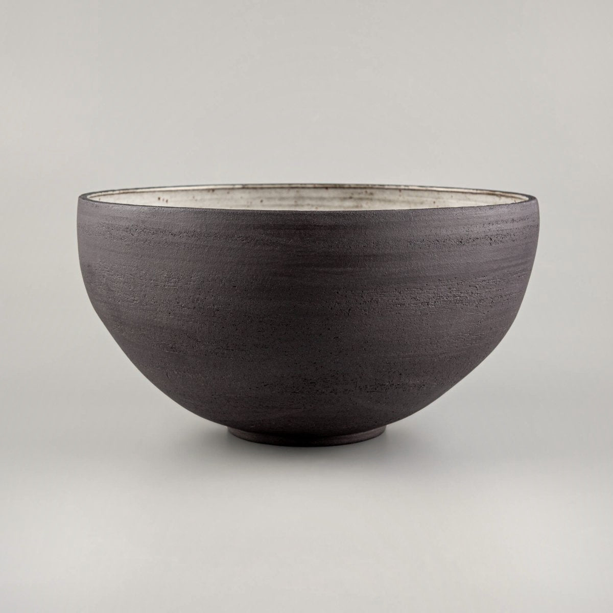 Decorative serving bowl showing cream speckled glaze, wheel-thrown lines, and fine dining serving shape.