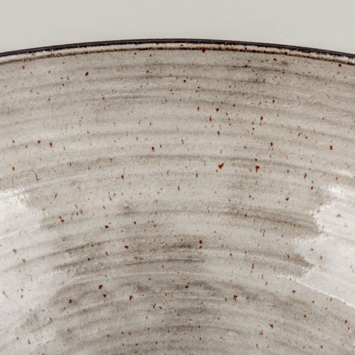 Close-up of handmade serving bowl exterior with charcoal clay texture, dark rim, and modern handmade decor feel.