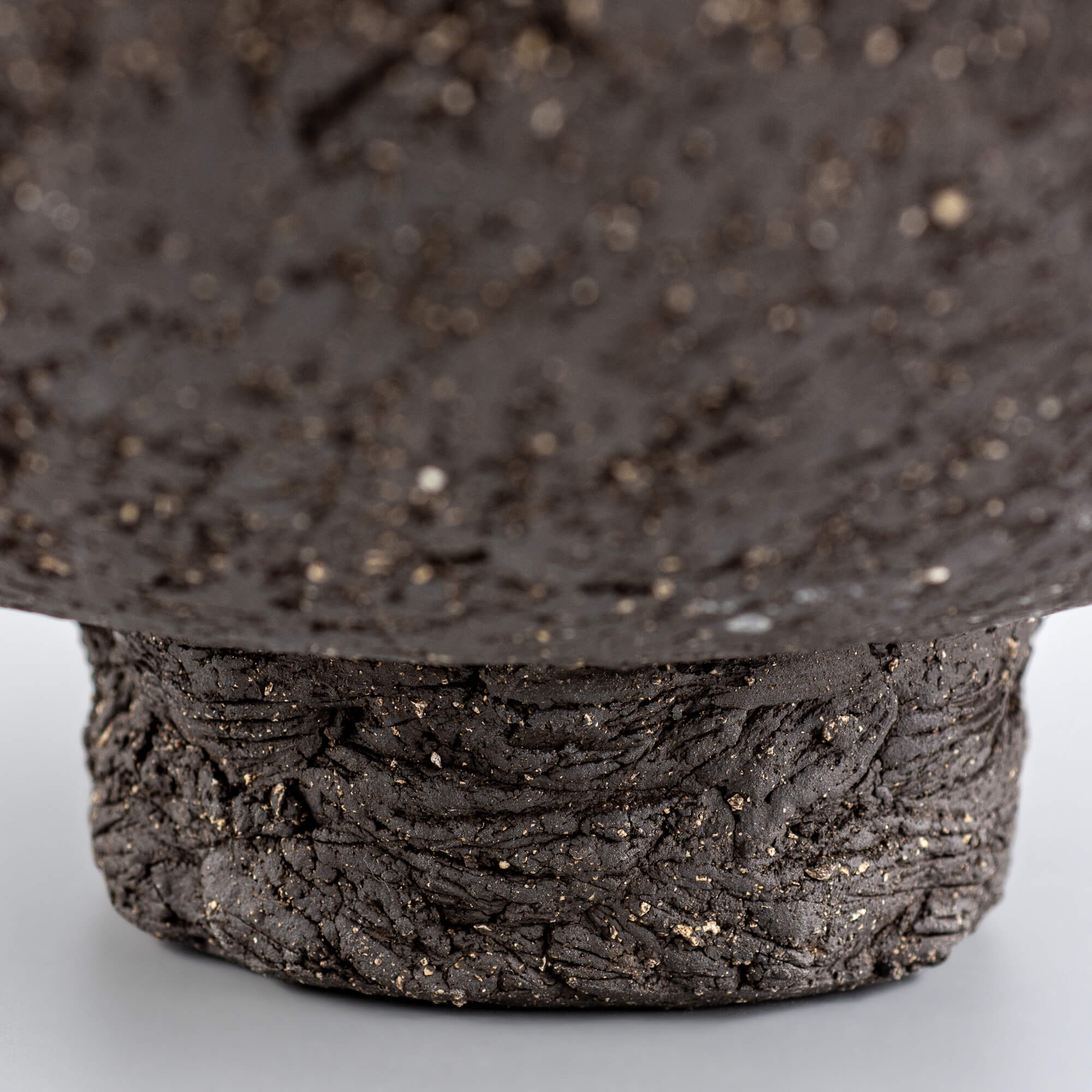Handcrafted centerpiece foot detail with rough ceramic texture for collectible pottery and interior design.