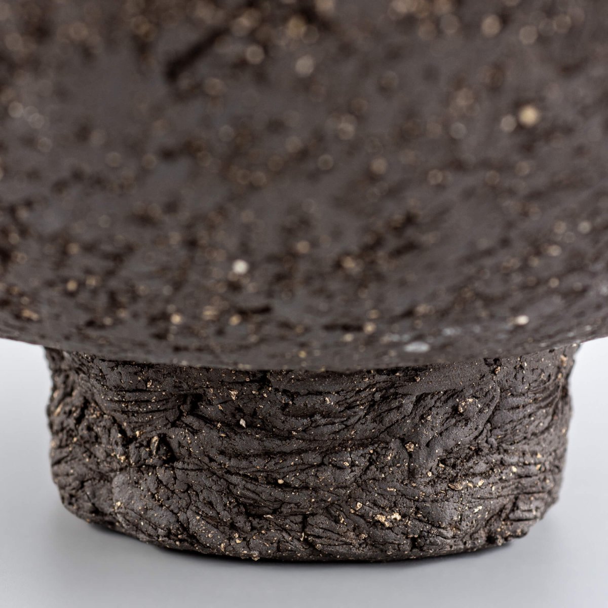 Handcrafted centerpiece foot detail with rough ceramic texture for collectible pottery and interior design.