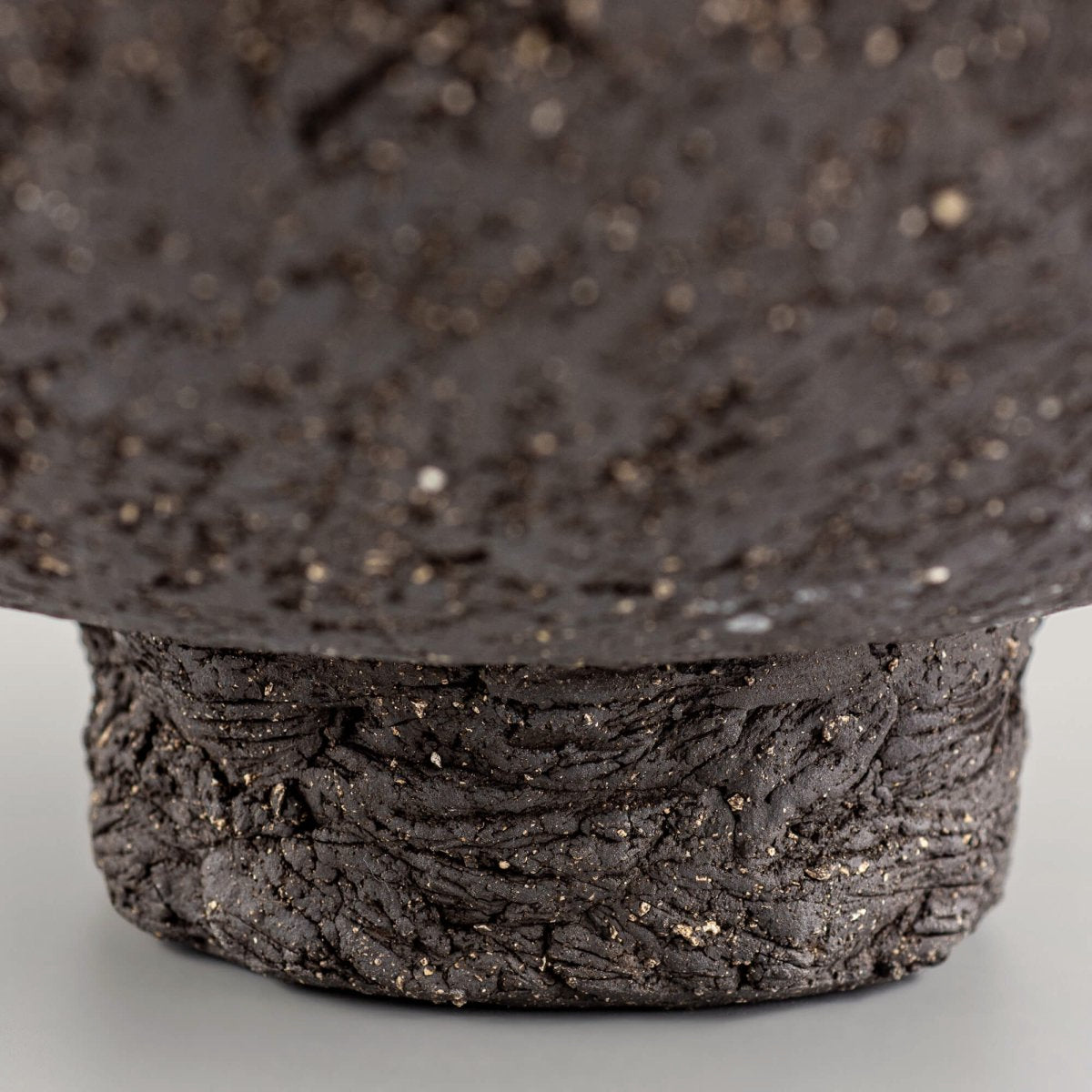 Handcrafted centerpiece foot detail with rough ceramic texture for collectible pottery and interior design.