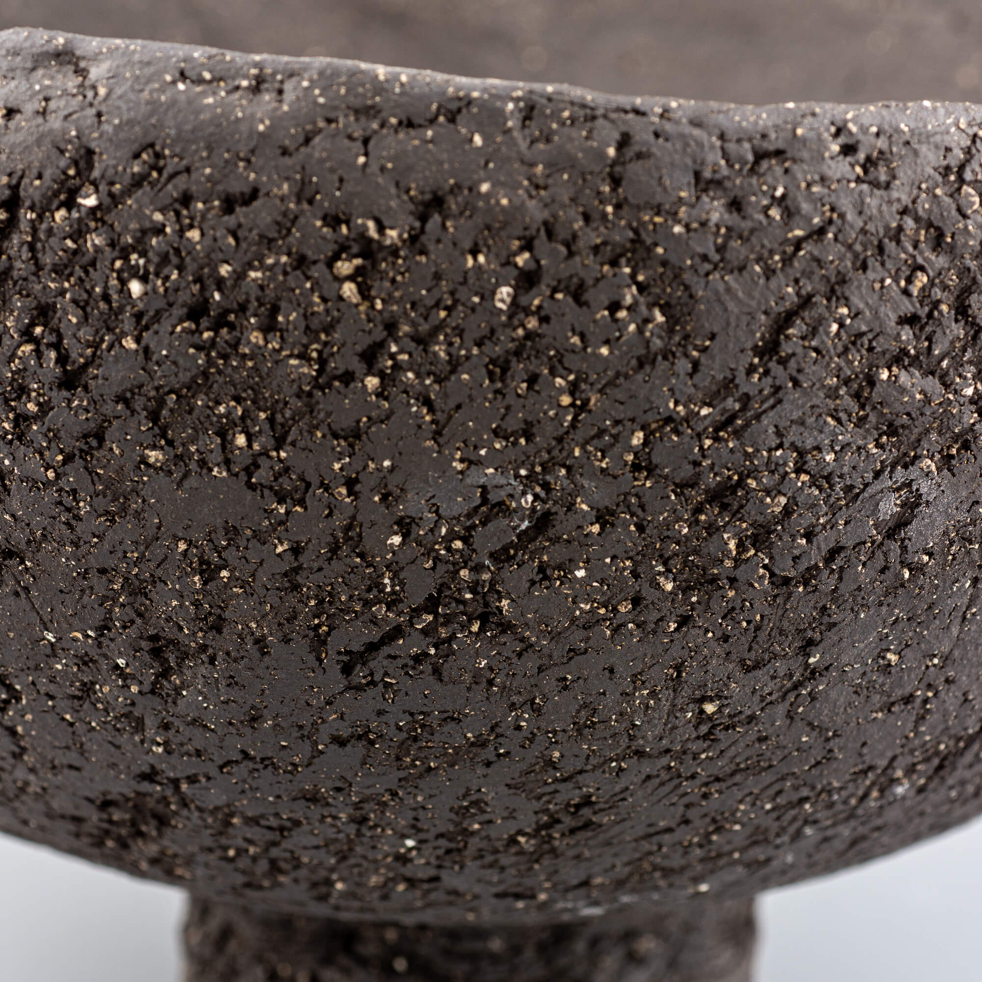 Handcrafted centerpiece close-up of uneven rim and metallic speckles for limited edition handmade decor.