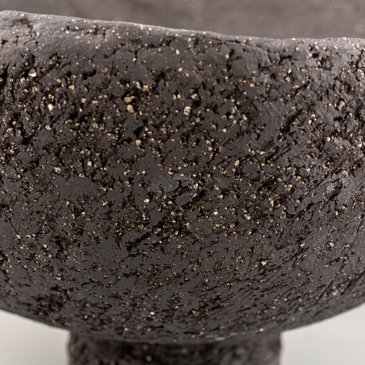 Handcrafted centerpiece close-up of uneven rim and metallic speckles for limited edition handmade decor.