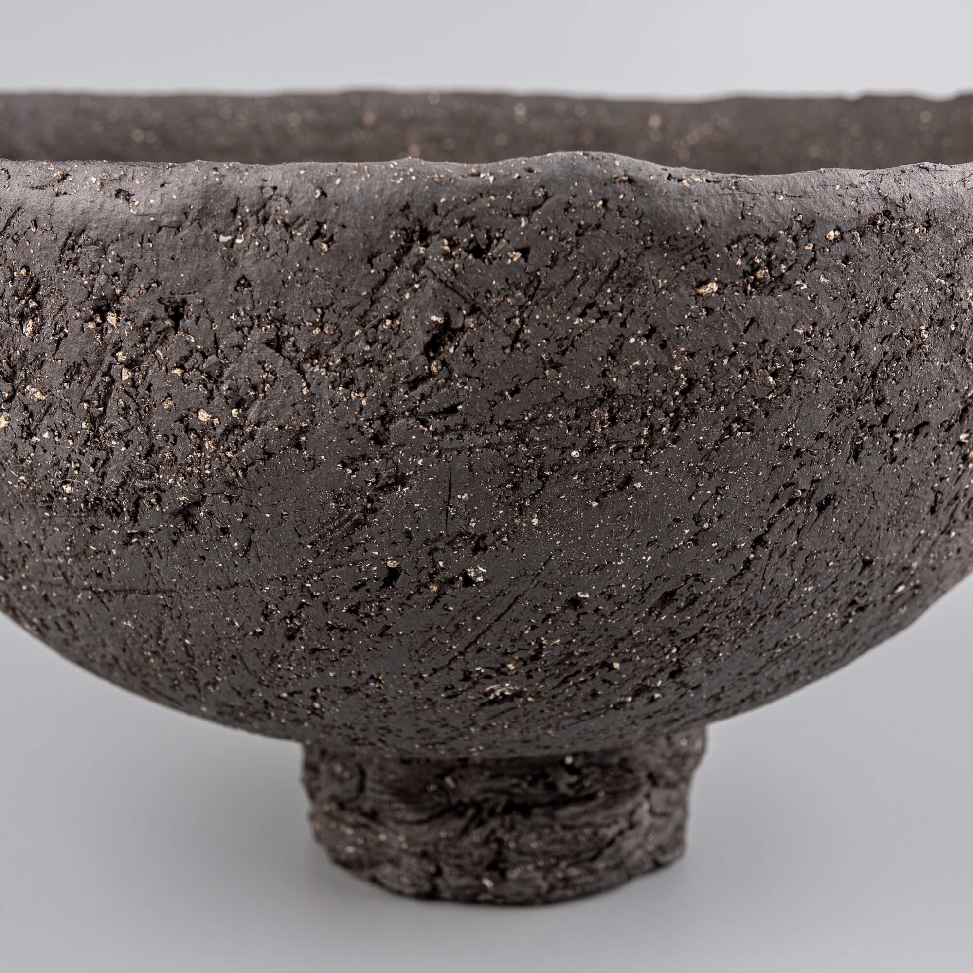 Handcrafted centerpiece close-up with dark textured ceramic surface for limited edition luxury home decor.