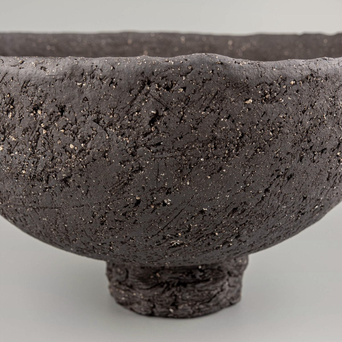 Handcrafted centerpiece close-up with dark textured ceramic surface for limited edition luxury home decor.