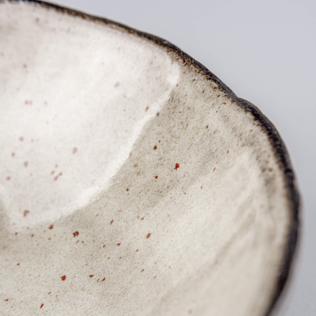 Exterior texture detail of a handmade ceramic bowl with carved surface, created for luxury dining and interior design.