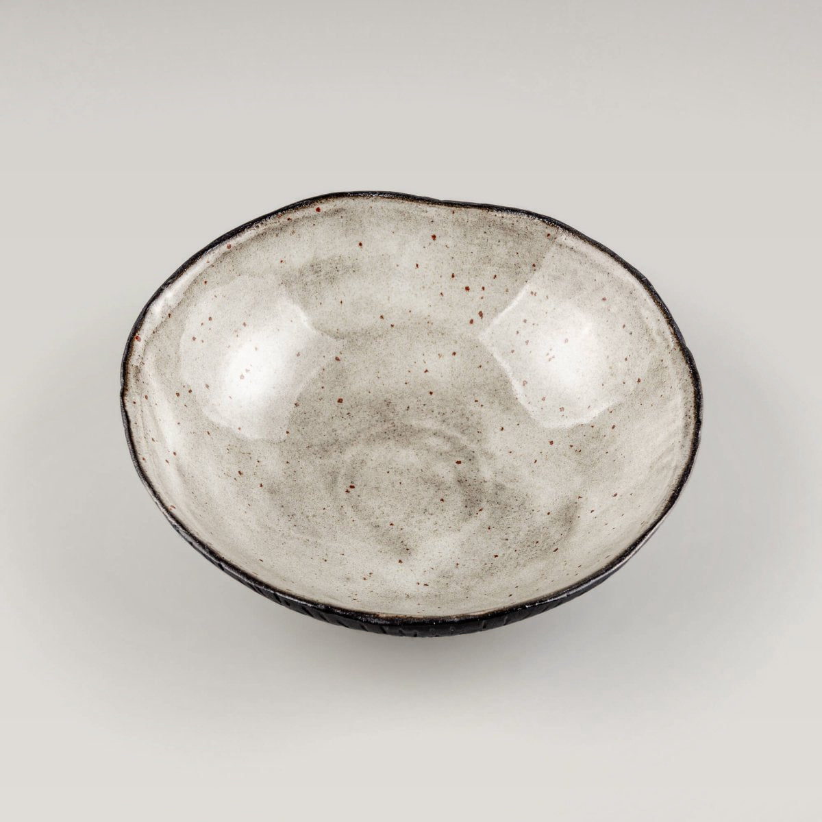 Top view of a handmade ceramic bowl with a natural speckled glaze, ideal for fine-dining restaurants and modern tableware.
