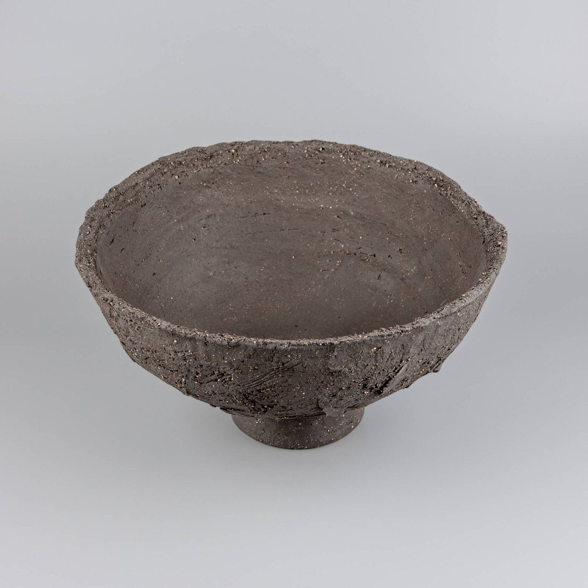 Handmade decorative bowl with deep charcoal clay texture, wide open shape, and centerpiece appeal for home or hotel decor.