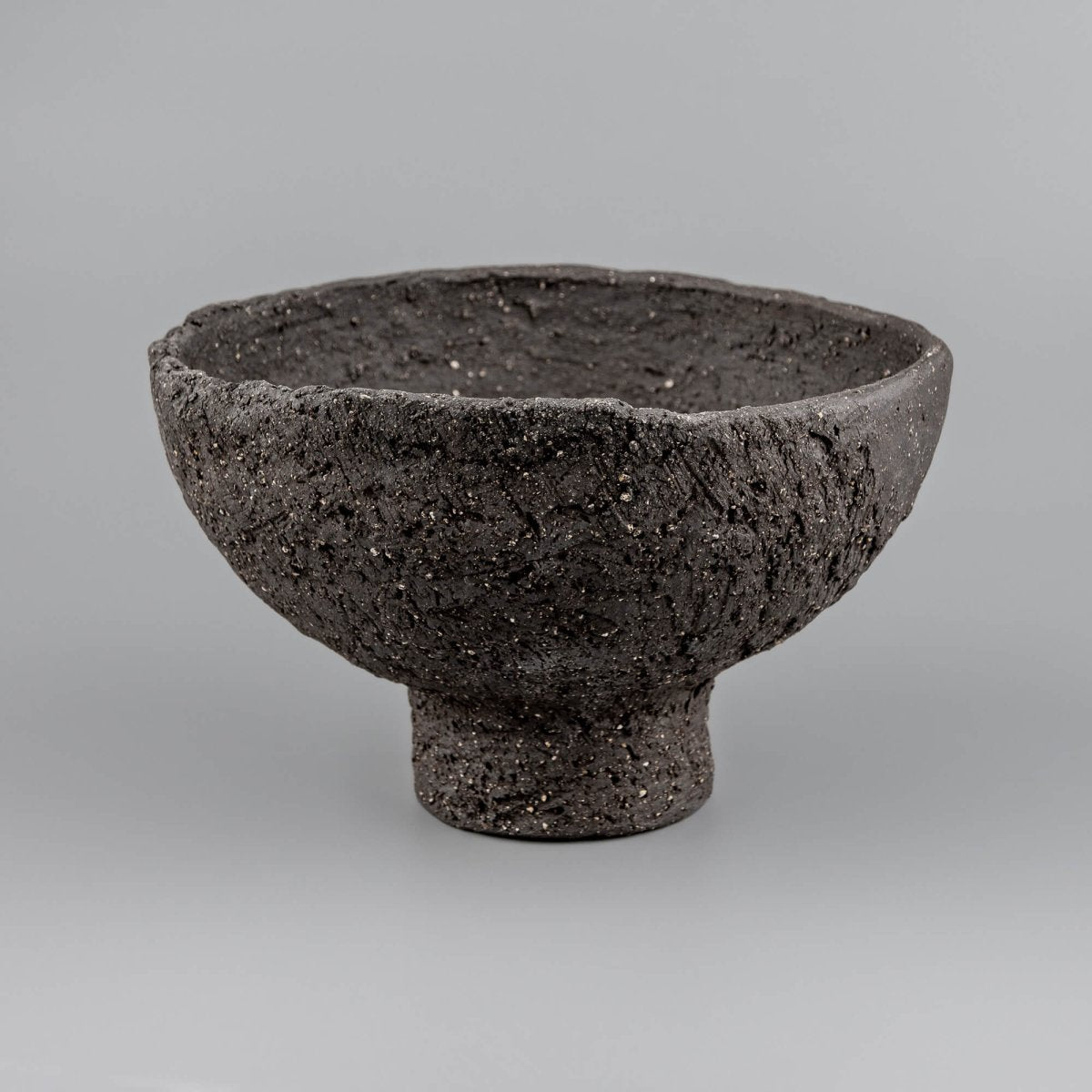 Angled view of handmade decorative bowl showing deep interior, raw rim, and sculptural form for boutique hotel styling.