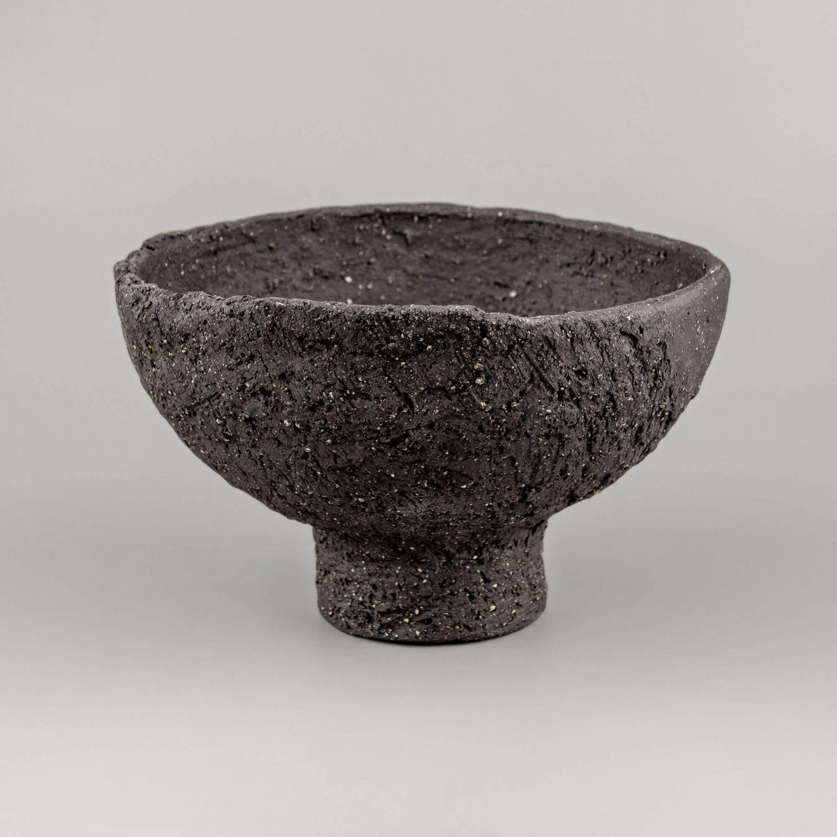 Angled view of handmade decorative bowl showing deep interior, raw rim, and sculptural form for boutique hotel styling.