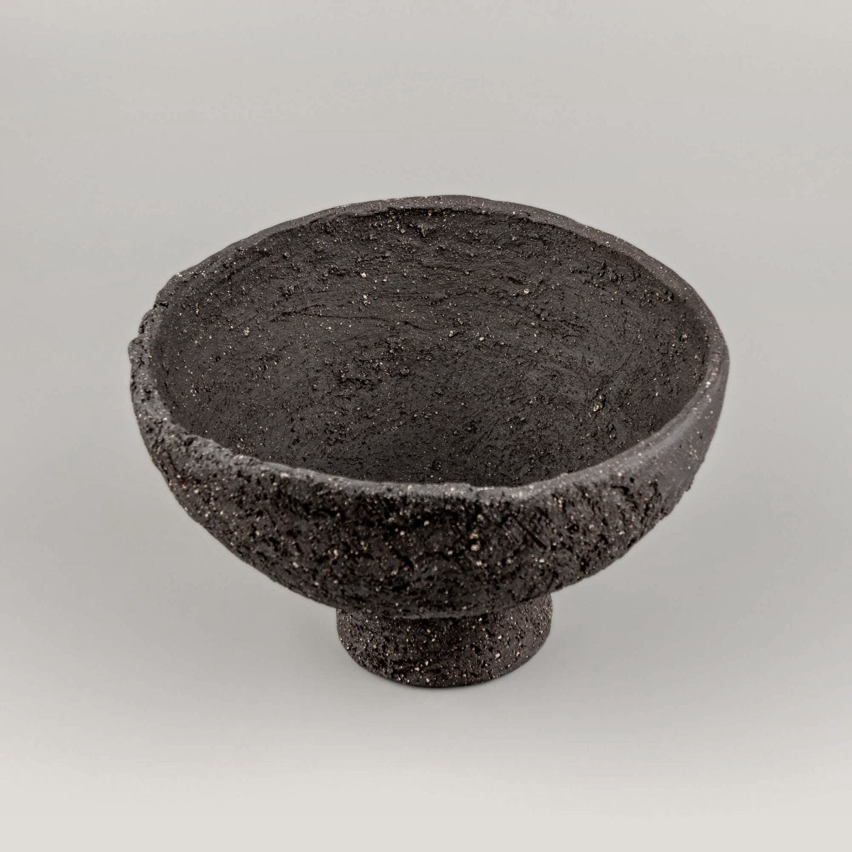 Top view of handmade decorative bowl with dark textured interior, irregular rim, and refined handmade decor character.