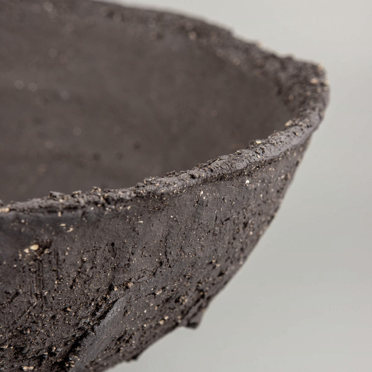 Handmade decorative bowl macro texture with charcoal clay, mineral speckles, and limited edition decor appeal.