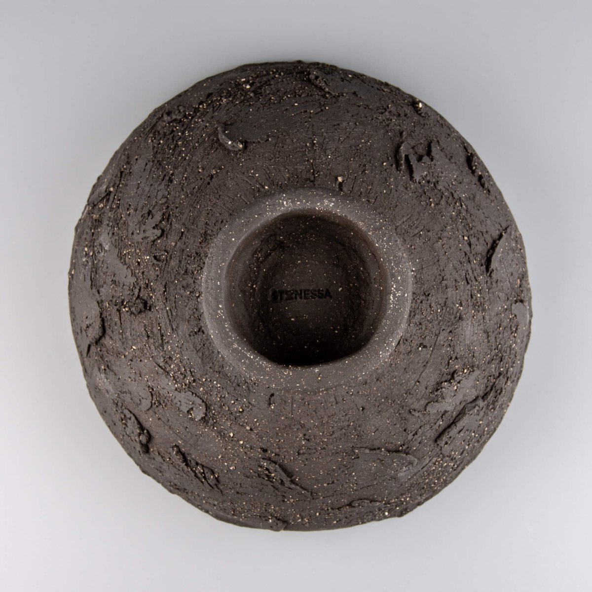 Handmade decorative bowl underside view with footed base, rough ceramic texture, and collectible pottery finish.