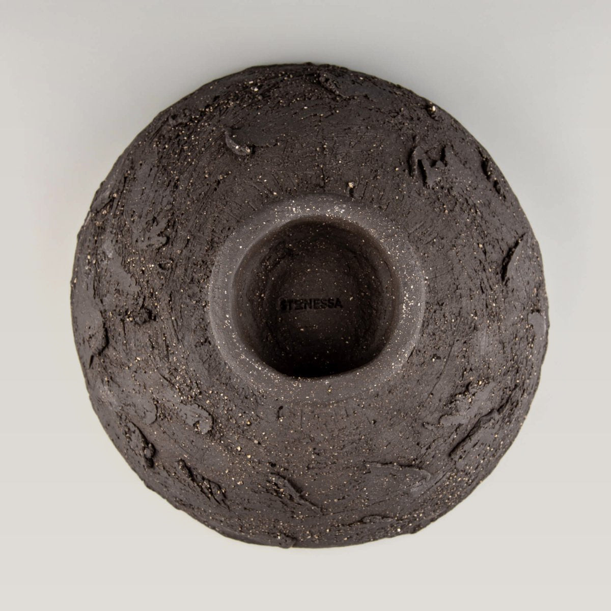 Handmade decorative bowl underside view with footed base, rough ceramic texture, and collectible pottery finish.