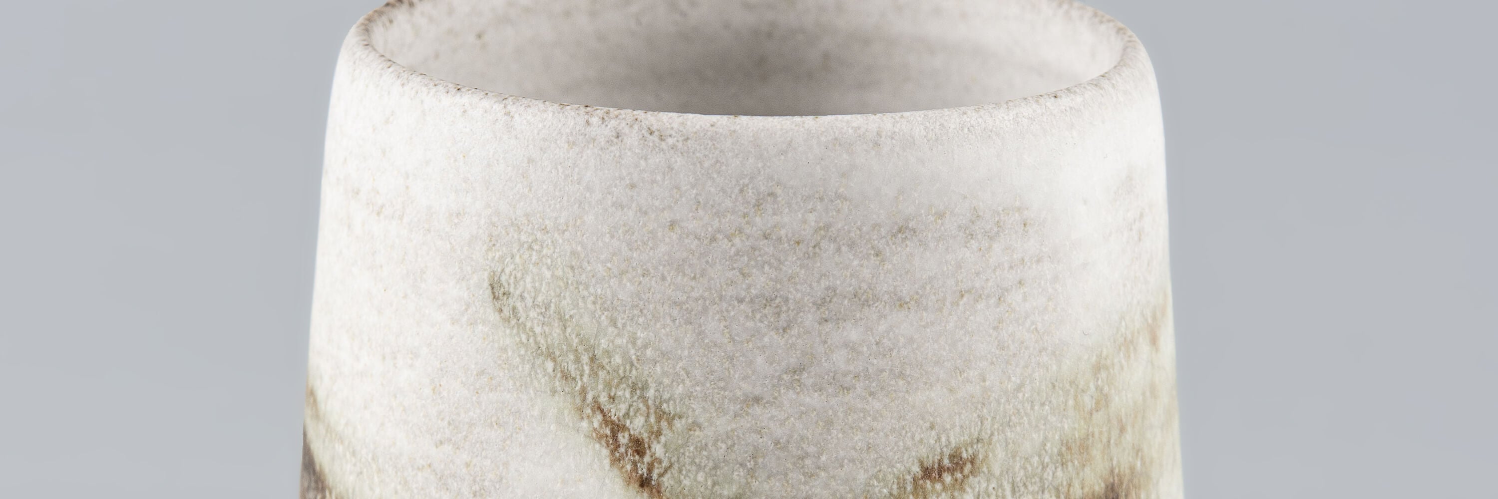 Handmade ceramic cup in artisanal white stoneware with subtle brown speckles, Stonessa design for modern coffee and espresso rituals.