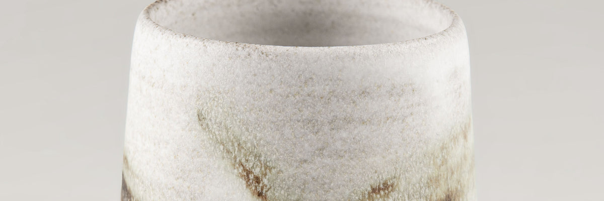 Handmade ceramic cup in artisanal white stoneware with subtle brown speckles, Stonessa design for modern coffee and espresso rituals.