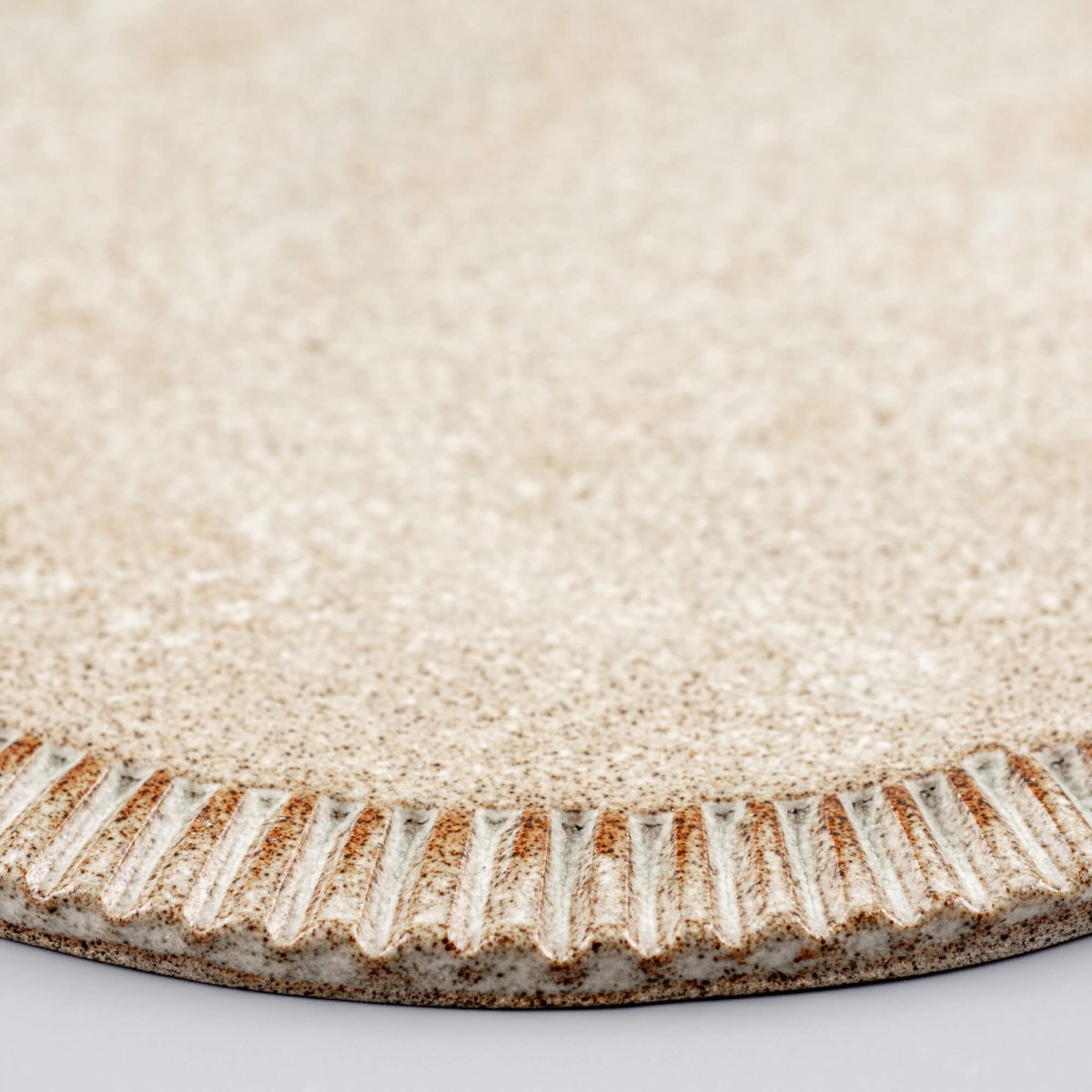 Rustic handmade ceramic plate with textured finish, suited for restaurant plating.