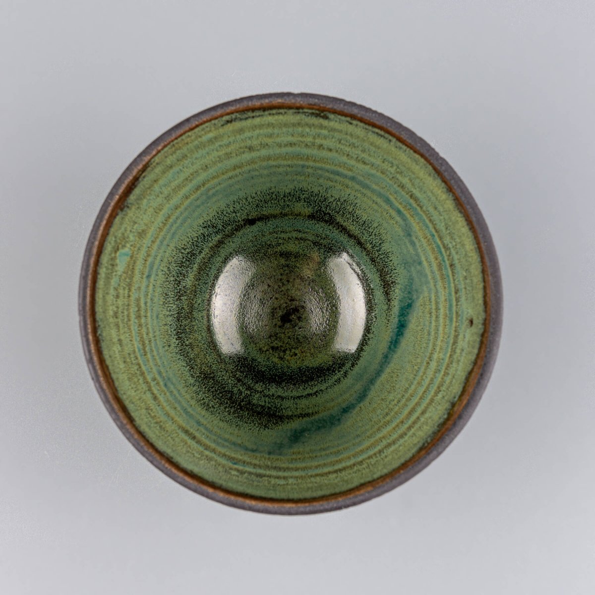 Green glazed ceramic bowl interior with natural handcrafted pottery finish.