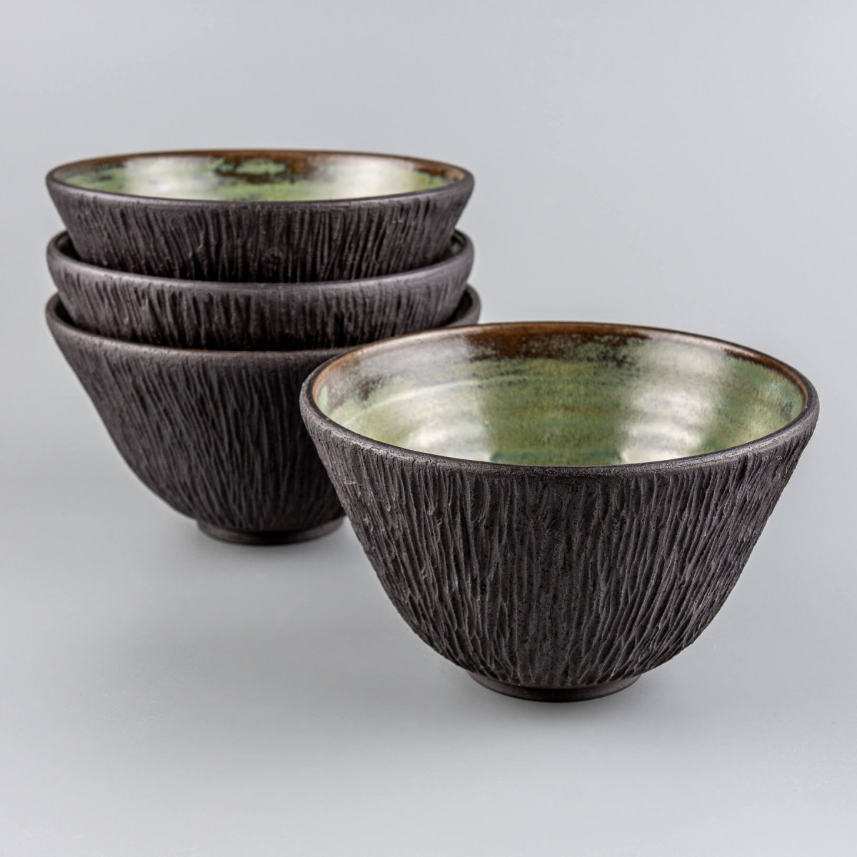 Fine dining ceramic tableware crafted from black stoneware clay with artistic detail.