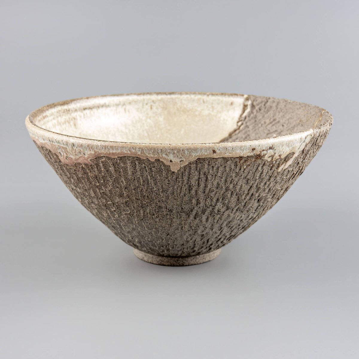 Handmade decorative bowl with textured stoneware exterior and matte glazed interior for home or fine dining centerpiece.