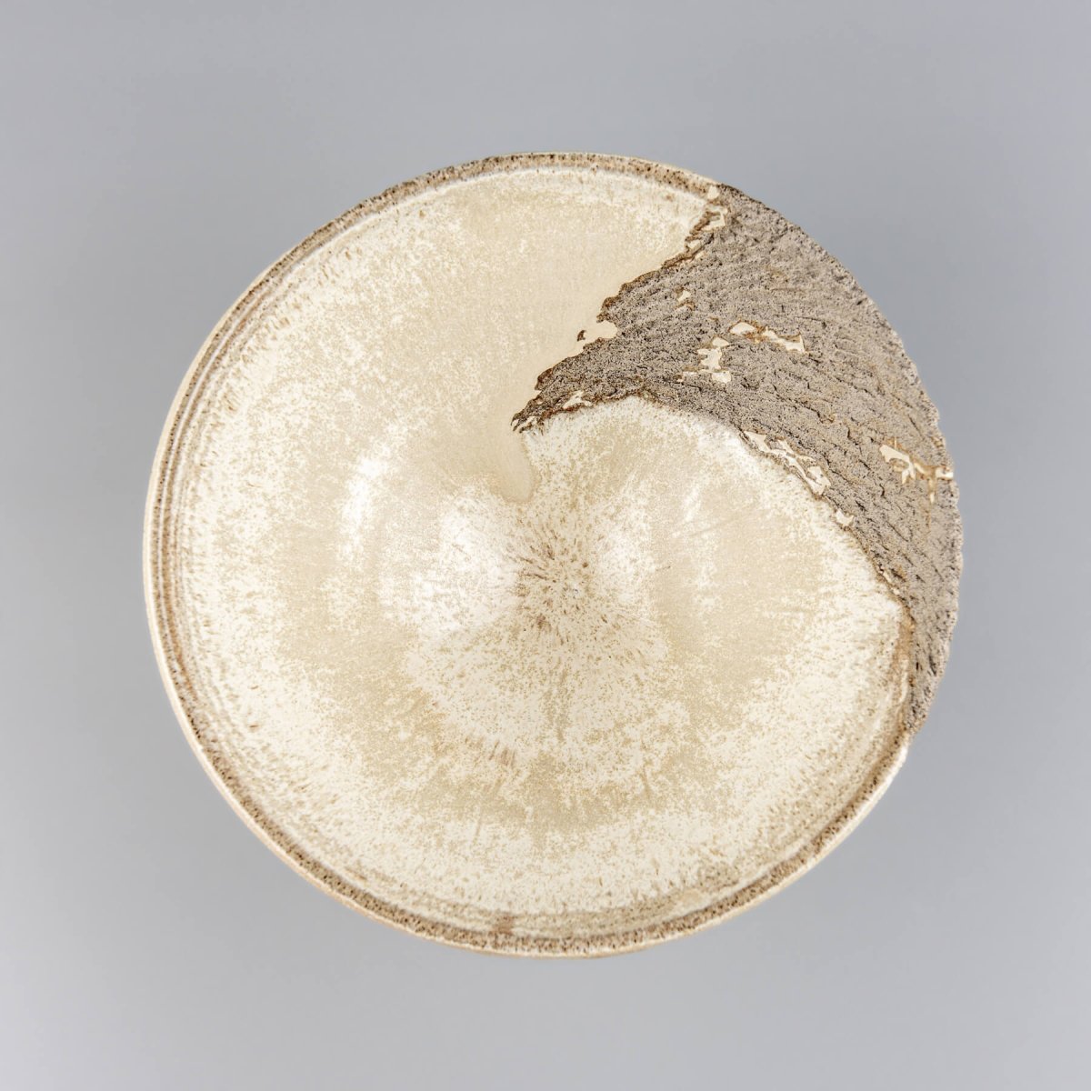Top view of artisan ceramic bowl showing ivory matte glaze and carved inner wall details.