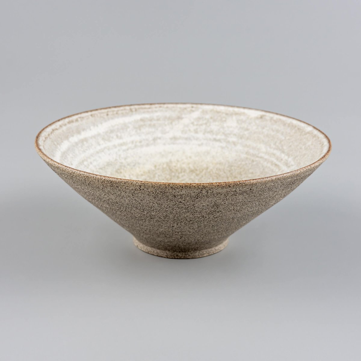 Sculptural ceramic bowl photographed diagonally to highlight its handmade, artisan shape.