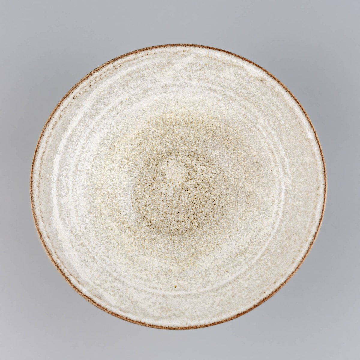 Top-down view of a handmade ceramic bowl showing smooth glazed interior and wide rim.