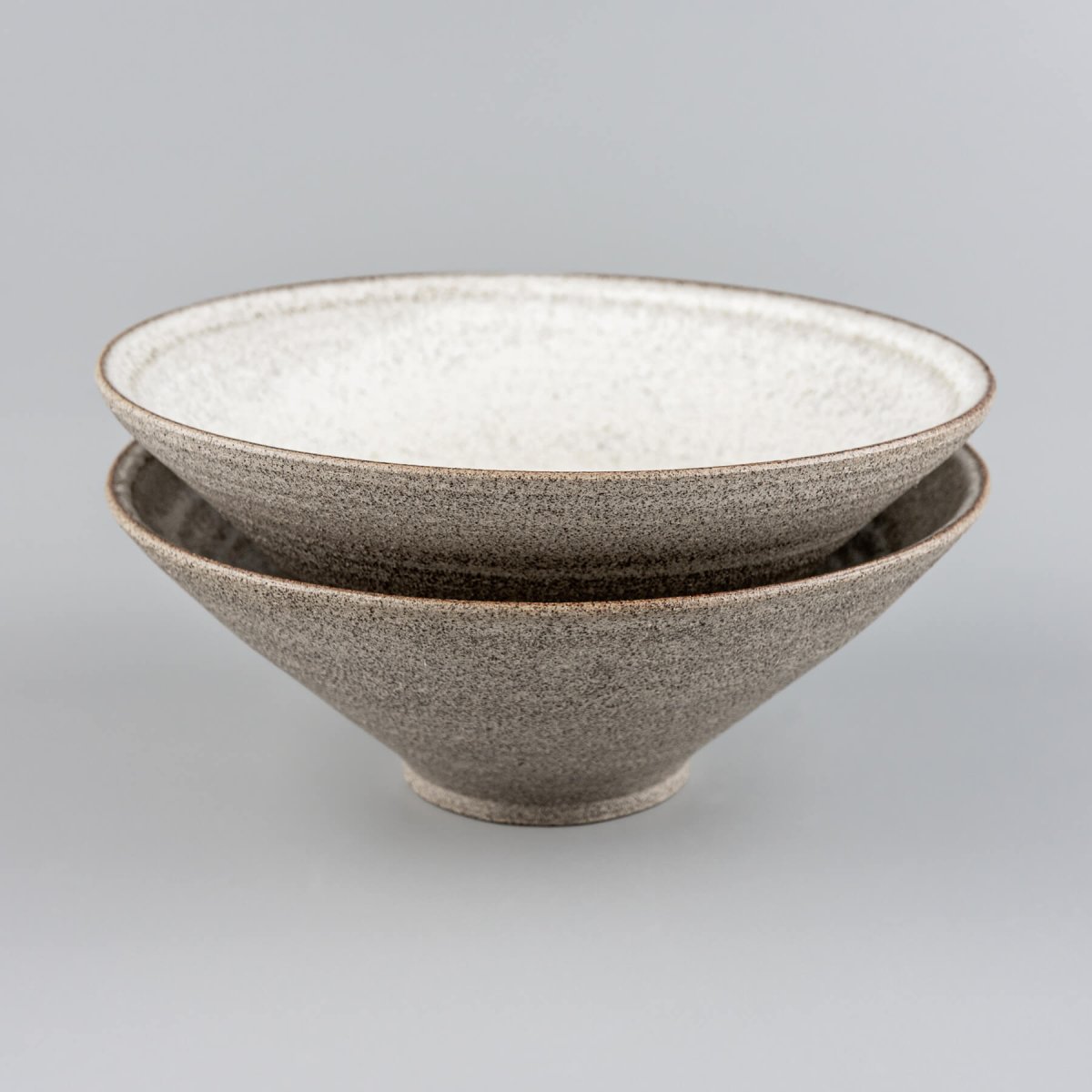 Profile view of handmade ceramic bowl with visible clay layers and artistic glaze finish.