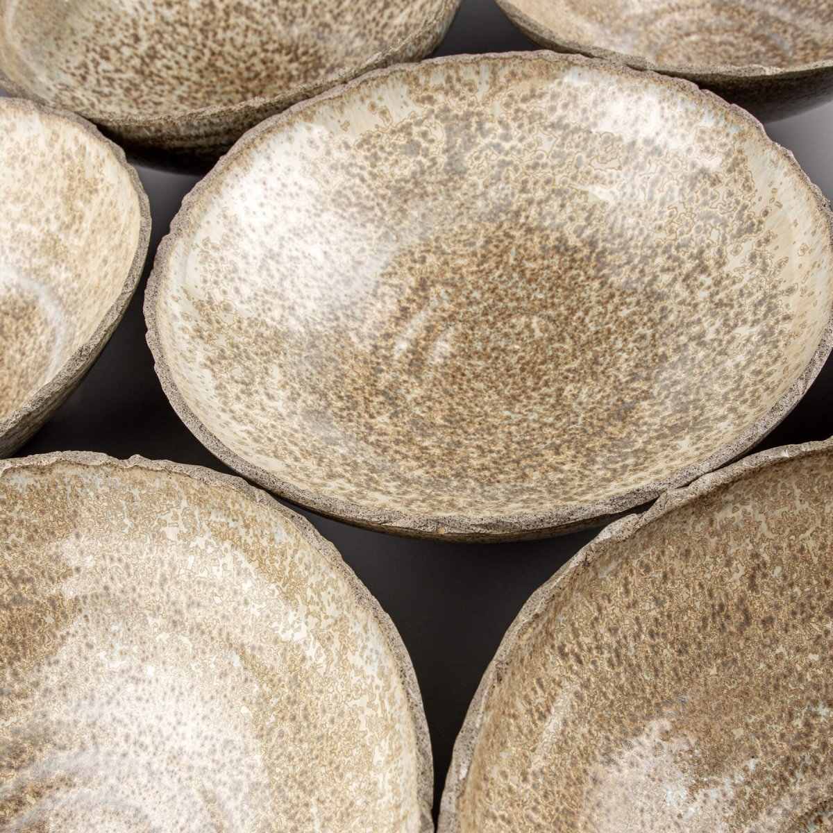 Arrangement of stoneware bowls showing handcrafted quality and organic ceramic aesthetics.