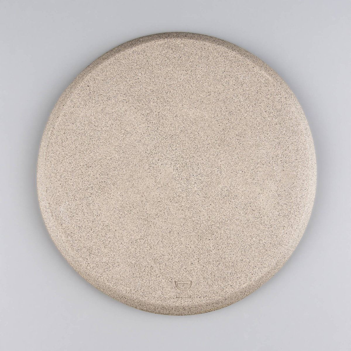 Unglazed underside of handmade plate highlighting raw stoneware clay.